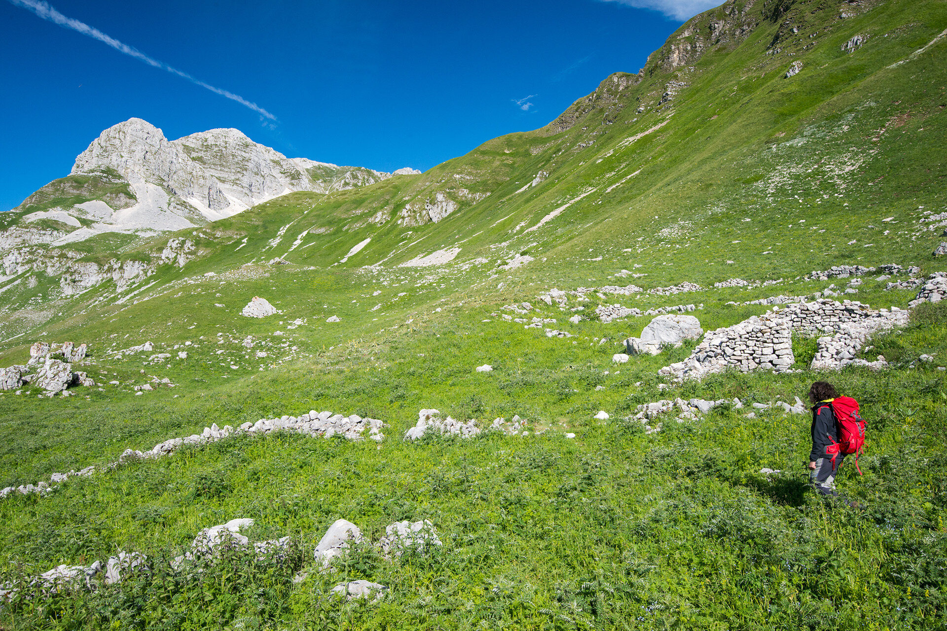 Un’escursionista attraversa gli antichi stazzi pastorali della Val Pagana, ai piedi del Monte Meta, nel cuore delle Mainarde.  | © Umberto Esposito - Wildlife Adventures